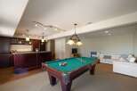 Experience ultimate entertainment in this finished basement featuring a full-service bar and a professional-grade pool table.