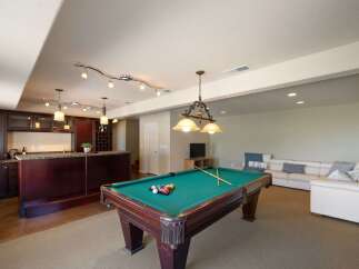 Experience ultimate entertainment in this finished basement featuring a full-service bar and a professional-grade pool table.