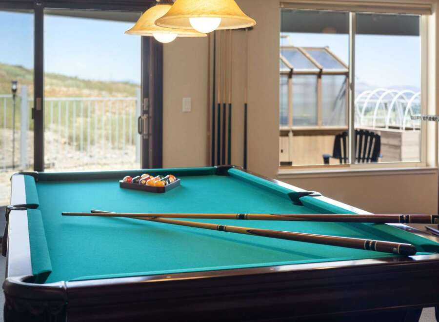 Enjoy endless entertainment in this home's dedicated game room, featuring a professional billiard table perfect for friendly competitions.