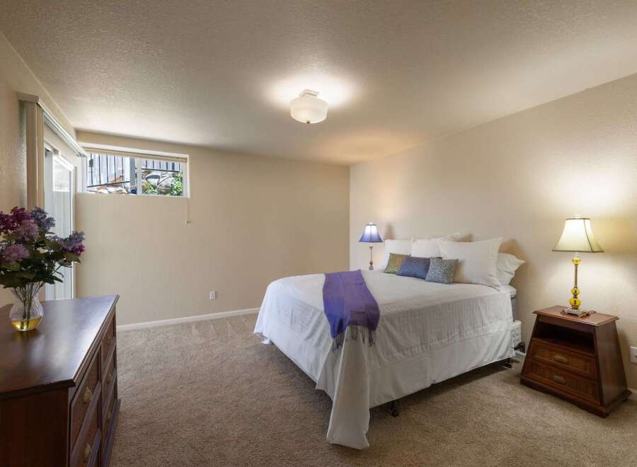 Discover comfort and style in this inviting bedroom, featuring a plush queen-size bed adorned with crisp white linens and decorative pillows.