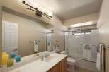 This bright and airy bathroom features a spacious vanity with ample counter space and a large mirror, perfect for your morning routine.