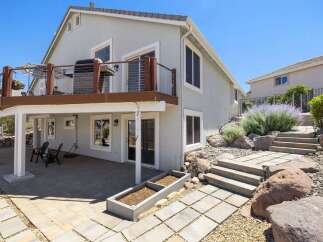 Enjoy outdoor living with this multi-level backyard featuring a spacious deck with a grill and seating area, perfect for entertaining.