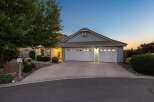 This charming single-story home features a welcoming facade with a well-maintained lawn and a spacious driveway leading to a two-car garage.
