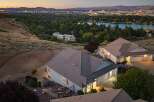 Experience breathtaking panoramic views from this stunning hillside estate, perfectly situated to capture the vibrant city lights and serene lake at dusk.
