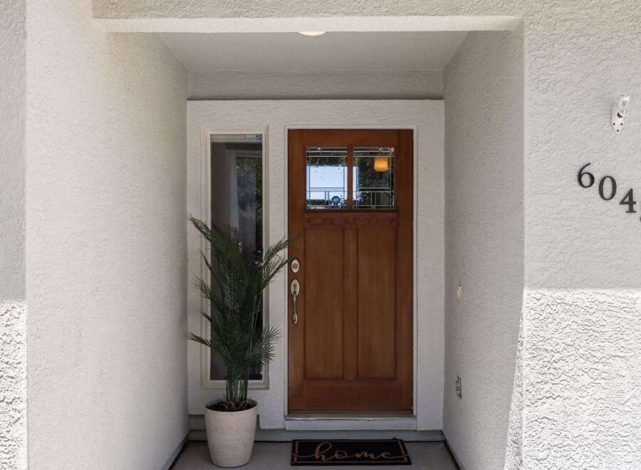 Welcome guests to this charming home with a beautiful wooden front door, featuring a decorative glass insert for natural light.