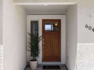 Welcome guests to this charming home with a beautiful wooden front door, featuring a decorative glass insert for natural light.