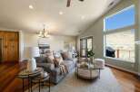 Experience breathtaking views from this stunning living room, featuring a vaulted ceiling and expansive windows that showcase the natural landscape.