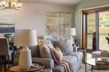 Experience comfortable living in this inviting living room, featuring a plush sofa adorned with decorative pillows and a cozy throw blanket.