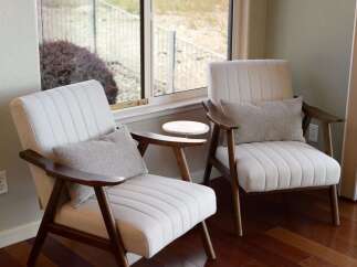 Relax in comfort and style in this inviting living space, featuring two plush armchairs perfect for quiet reading or conversation.