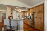 This spacious kitchen boasts beautiful natural wood cabinetry and a large stainless steel refrigerator, perfect for any home chef.