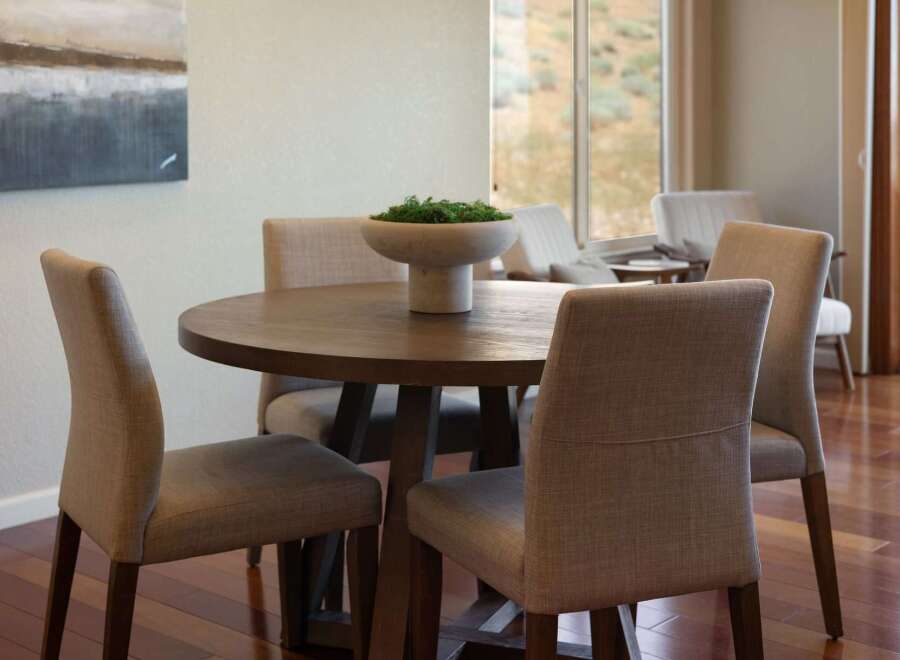 This dining area features a round wooden table with upholstered chairs, perfect for intimate gatherings.