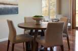 This dining area features a round wooden table with upholstered chairs, perfect for intimate gatherings.
