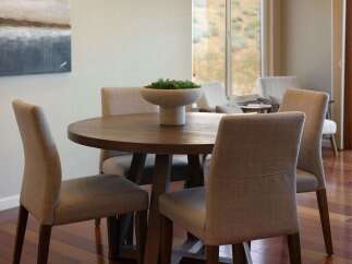 This dining area features a round wooden table with upholstered chairs, perfect for intimate gatherings.