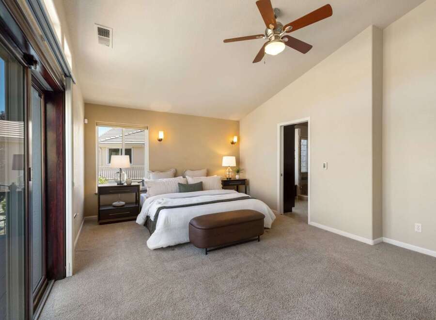 Experience ultimate comfort in this spacious master bedroom, featuring a vaulted ceiling and a modern ceiling fan for optimal air circulation.