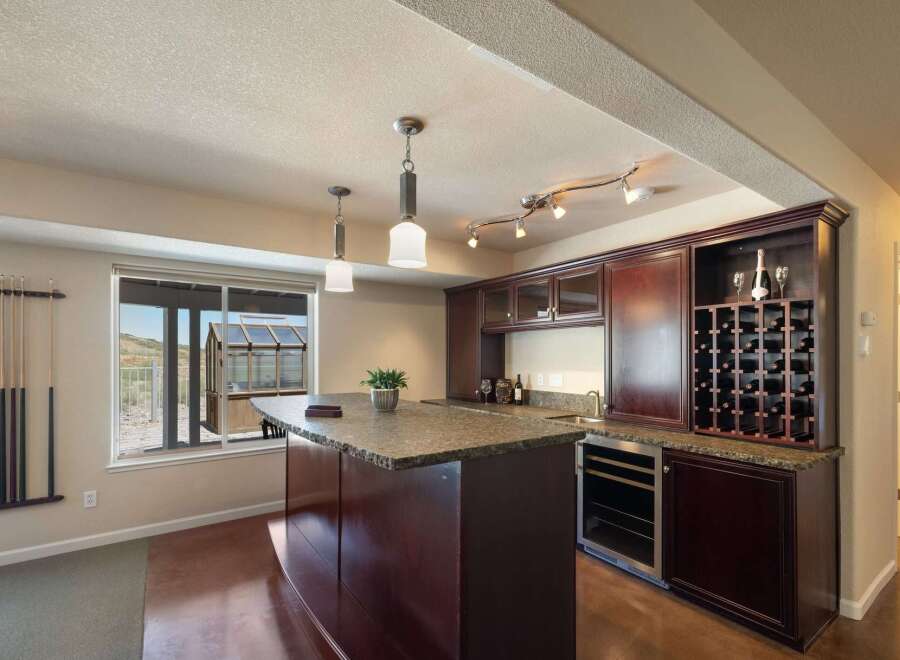Entertain in style in this stunning home bar area, complete with a granite-topped island and a built-in wine rack.