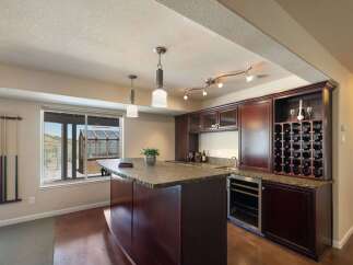 Entertain in style in this stunning home bar area, complete with a granite-topped island and a built-in wine rack.