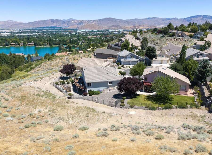 Experience breathtaking panoramic views from this stunning hillside estate, overlooking a serene lake and majestic mountains.