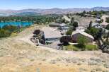 Experience breathtaking panoramic views from this stunning hillside estate, overlooking a serene lake and majestic mountains.