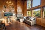Experience rustic charm in this stunning living room, featuring a grand stone fireplace and a beautiful wood-paneled accent wall.