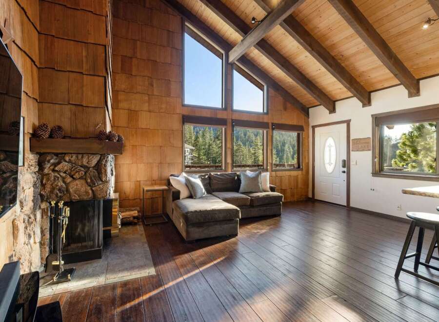 Experience rustic charm in this mountain retreat featuring a stunning stone fireplace and soaring vaulted ceilings with exposed wooden beams.