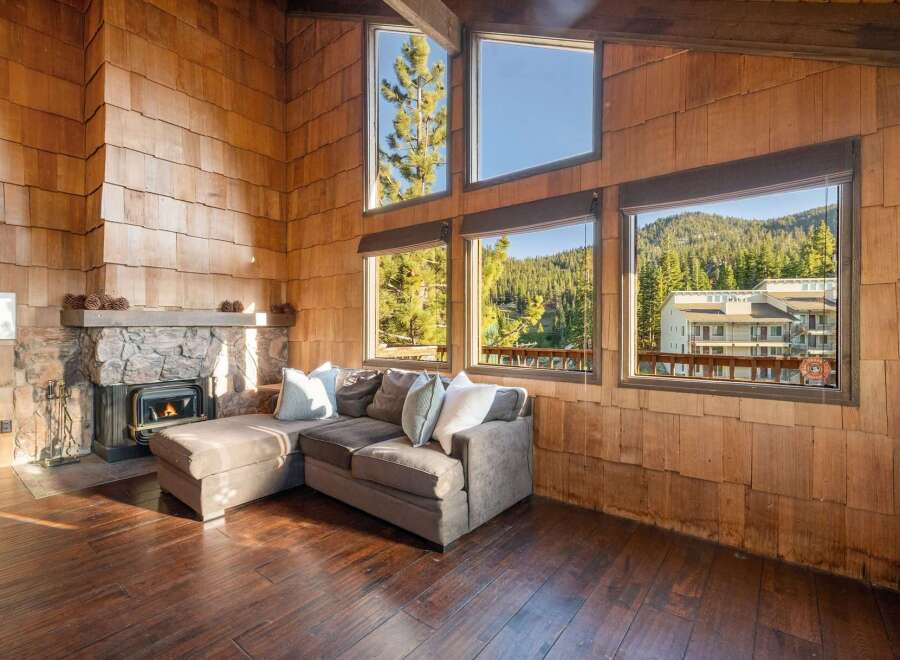 Experience rustic charm in this cozy living room featuring a stone fireplace and a plush sectional sofa perfect for relaxing.