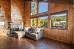 Experience rustic charm in this cozy living room featuring a stone fireplace and a plush sectional sofa perfect for relaxing.