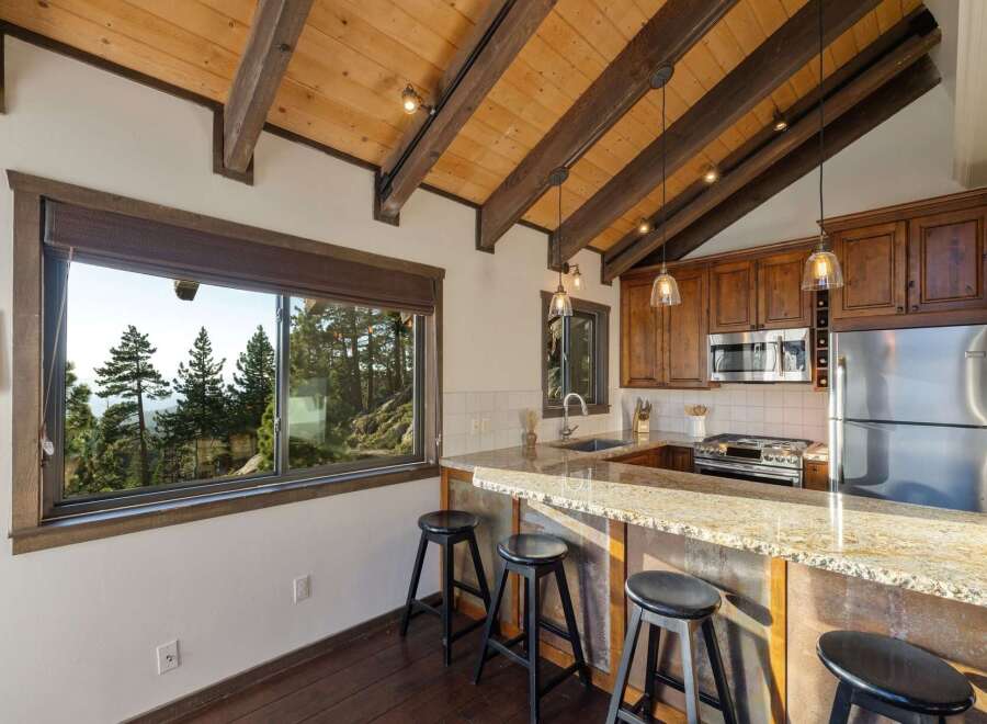Experience breathtaking mountain views from this charming kitchen, featuring a spacious granite countertop bar perfect for casual dining.