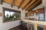 Experience breathtaking mountain views from this charming kitchen, featuring a spacious granite countertop bar perfect for casual dining.