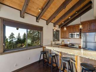 Experience breathtaking mountain views from this charming kitchen, featuring a spacious granite countertop bar perfect for casual dining.