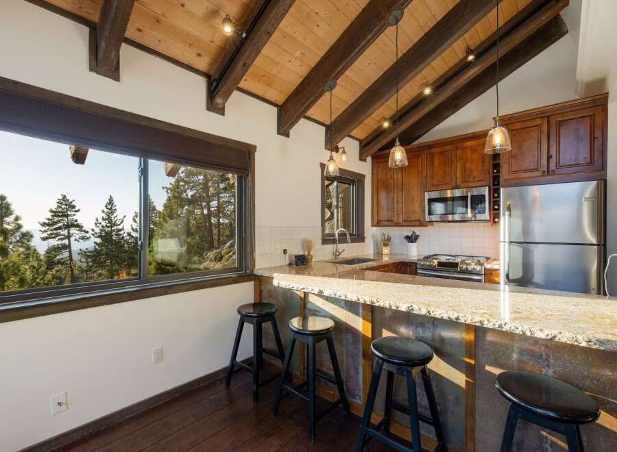 Experience breathtaking mountain views from this stunning kitchen, featuring a spacious granite countertop island perfect for casual dining.