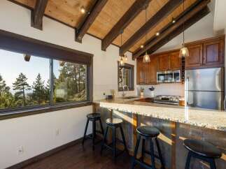 Experience breathtaking mountain views from this stunning kitchen, featuring a spacious granite countertop island perfect for casual dining.