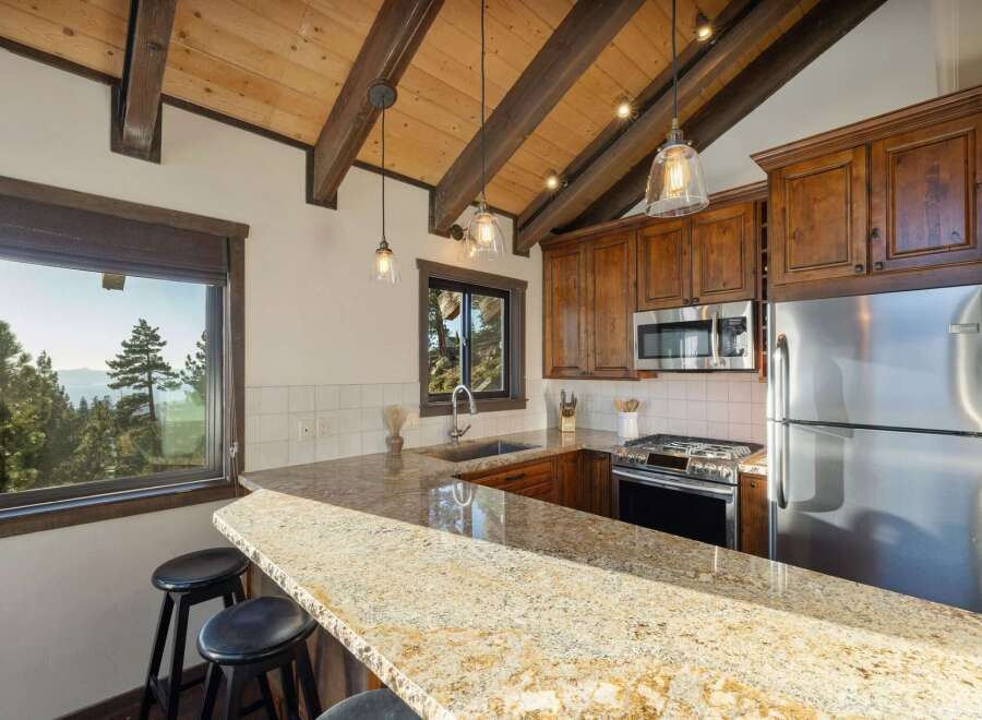 Experience breathtaking mountain views from this charming kitchen, featuring a spacious granite countertop island perfect for casual dining.