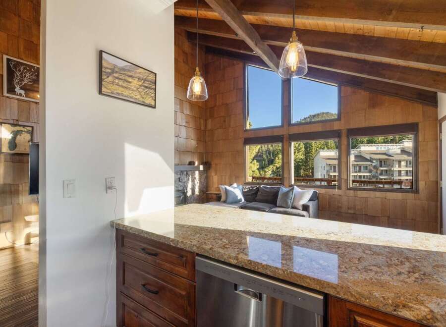 Experience breathtaking mountain views from this stunning living space, featuring a cozy fireplace and expansive windows that flood the room with natural light.