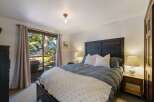 Experience ultimate relaxation in this serene bedroom, featuring a comfortable king-size bed adorned with plush pillows and a cozy duvet.