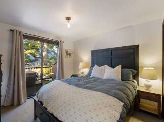 Experience ultimate relaxation in this serene bedroom, featuring a comfortable king-size bed adorned with plush pillows and a cozy duvet.