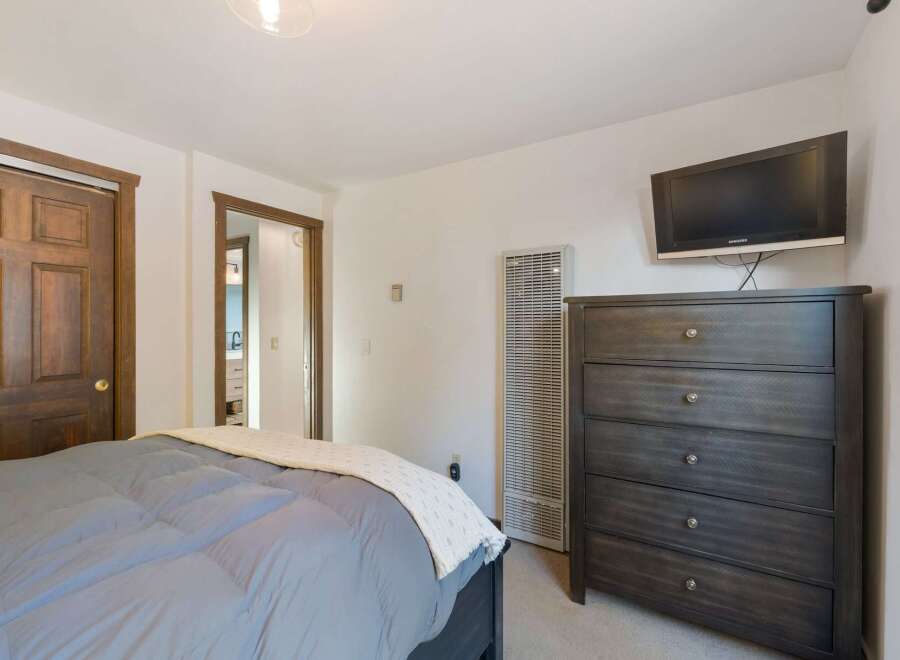 This cozy bedroom features a comfortable bed with a plush duvet and a decorative throw.