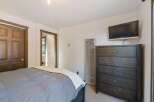 This cozy bedroom features a comfortable bed with a plush duvet and a decorative throw.