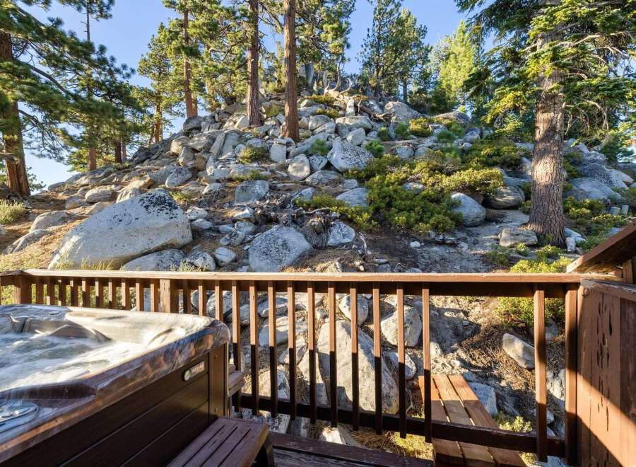 Enjoy ultimate relaxation in this stunning property featuring a luxurious hot tub overlooking a picturesque rocky hillside dotted with mature pine trees.