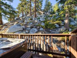 Enjoy ultimate relaxation in this stunning property featuring a luxurious hot tub overlooking a picturesque rocky hillside dotted with mature pine trees.