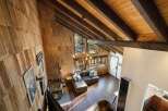 Experience rustic charm in this stunning mountain retreat, featuring a grand living area with a soaring wood-beamed ceiling and a striking stone fireplace.
