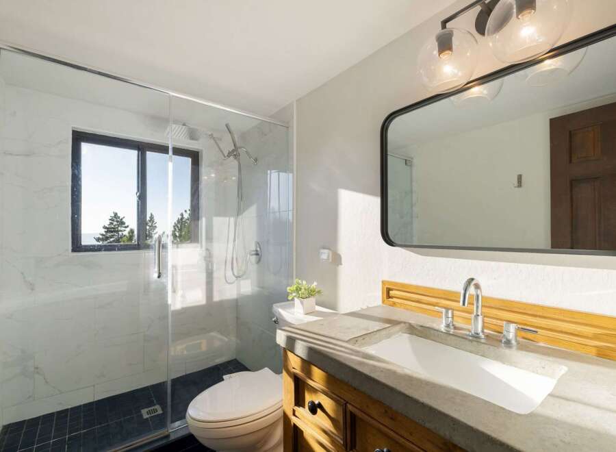 Experience modern luxury in this stunning bathroom, featuring a sleek glass-enclosed shower with marble tile and a convenient toilet.