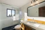 Experience modern luxury in this stunning bathroom, featuring a sleek glass-enclosed shower with marble tile and a convenient toilet.