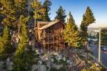 Experience breathtaking mountain views from this stunning wooden lodge, nestled amidst towering pine trees and rocky terrain.