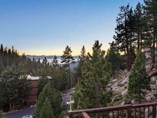 Experience breathtaking lake and mountain views from this stunning property nestled among pine trees.