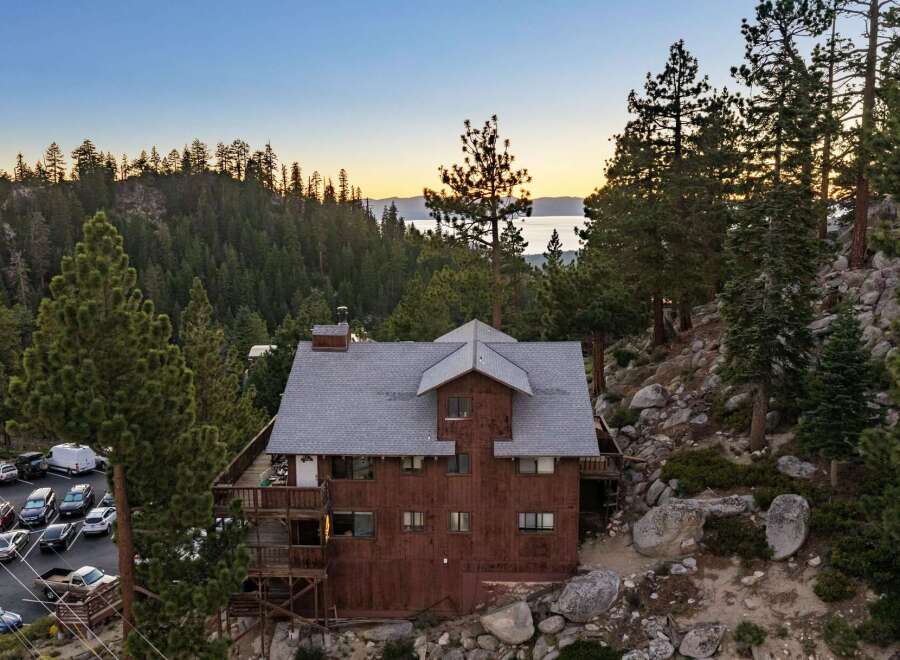 Nestled amidst a serene forest landscape, this charming rustic home offers breathtaking lake views at sunset.