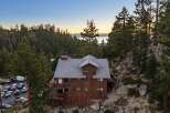 Nestled amidst a serene forest landscape, this charming rustic home offers breathtaking lake views at sunset.