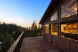 Experience breathtaking sunset views from this stunning mountain home, featuring a spacious wooden deck perfect for outdoor entertaining.
