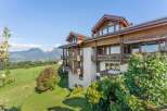 Experience breathtaking mountain views from this stunning property, featuring a modern wooden exterior and multiple balconies perfect for enjoying the scenery.