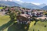 Experience breathtaking mountain views from this stunning alpine property, featuring traditional wooden architecture and spacious balconies perfect for enjoying the scenery.