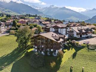 Experience breathtaking mountain views from this stunning alpine property, featuring traditional wooden architecture and spacious balconies perfect for enjoying the scenery.